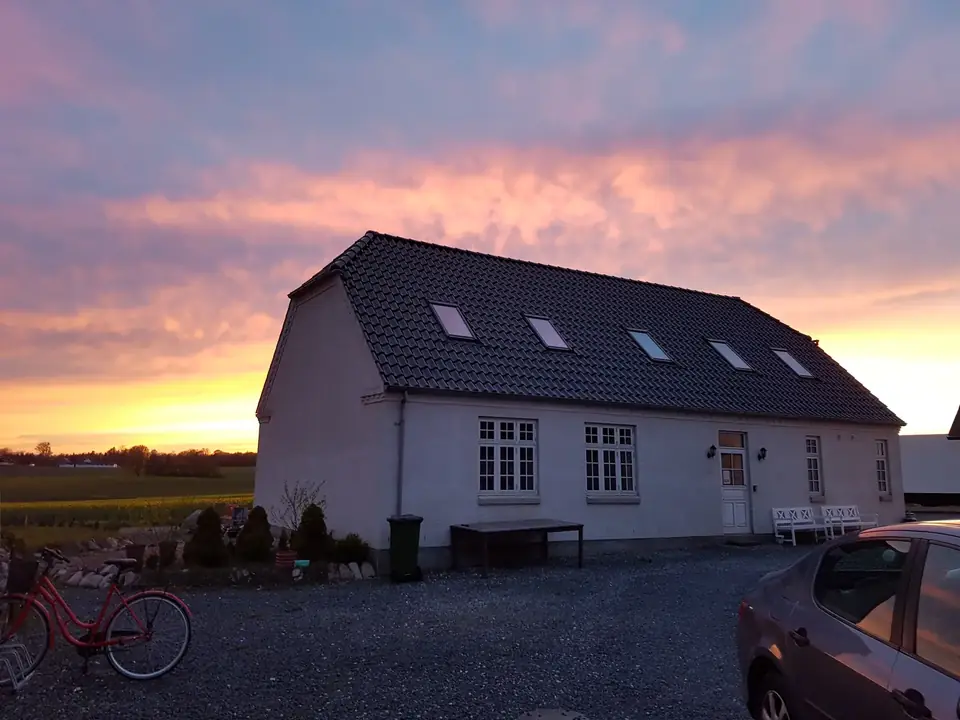 Huset under en rosa aftenhimmel