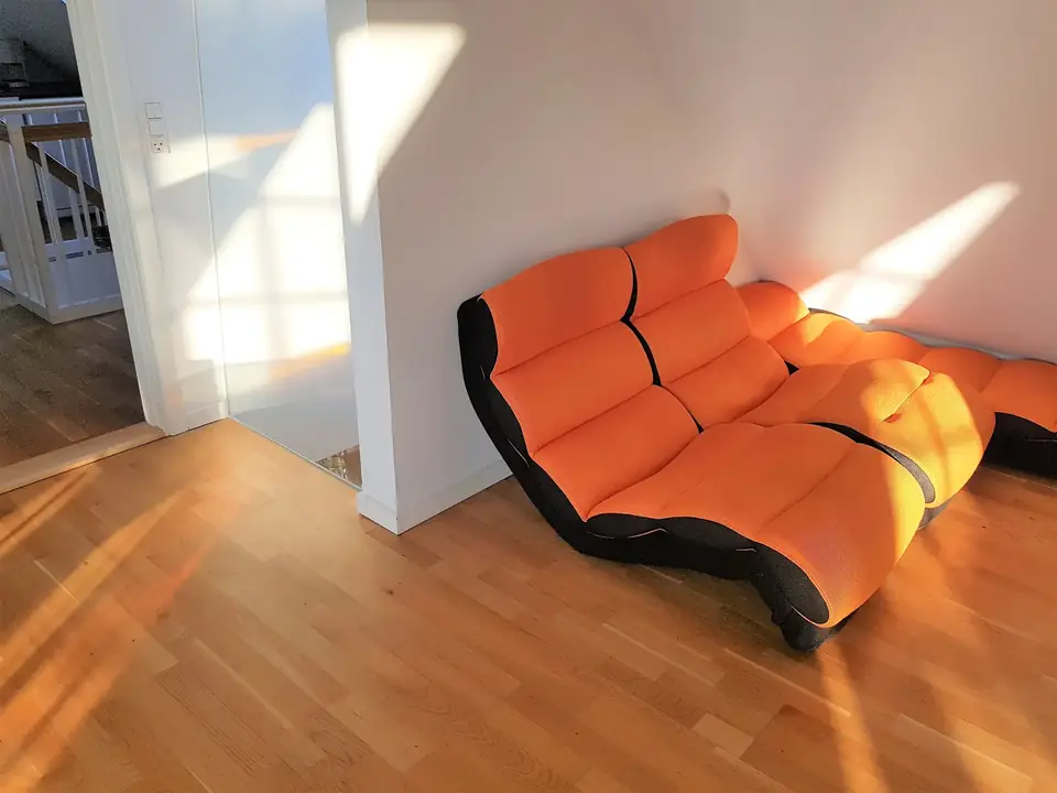 Orange sofa under skråvæggen